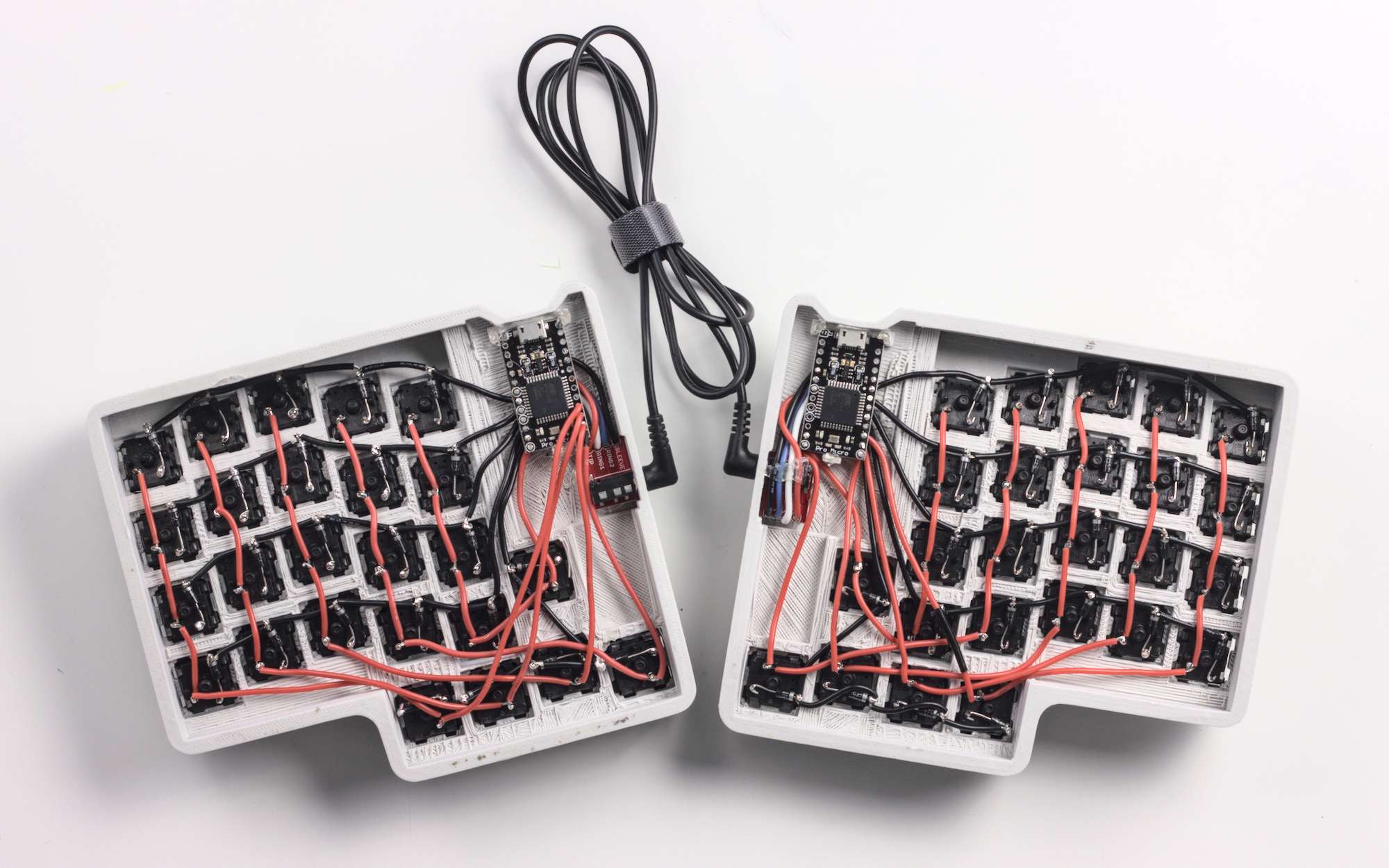 The underside of the split keyboard, showing exposed wiring to each key