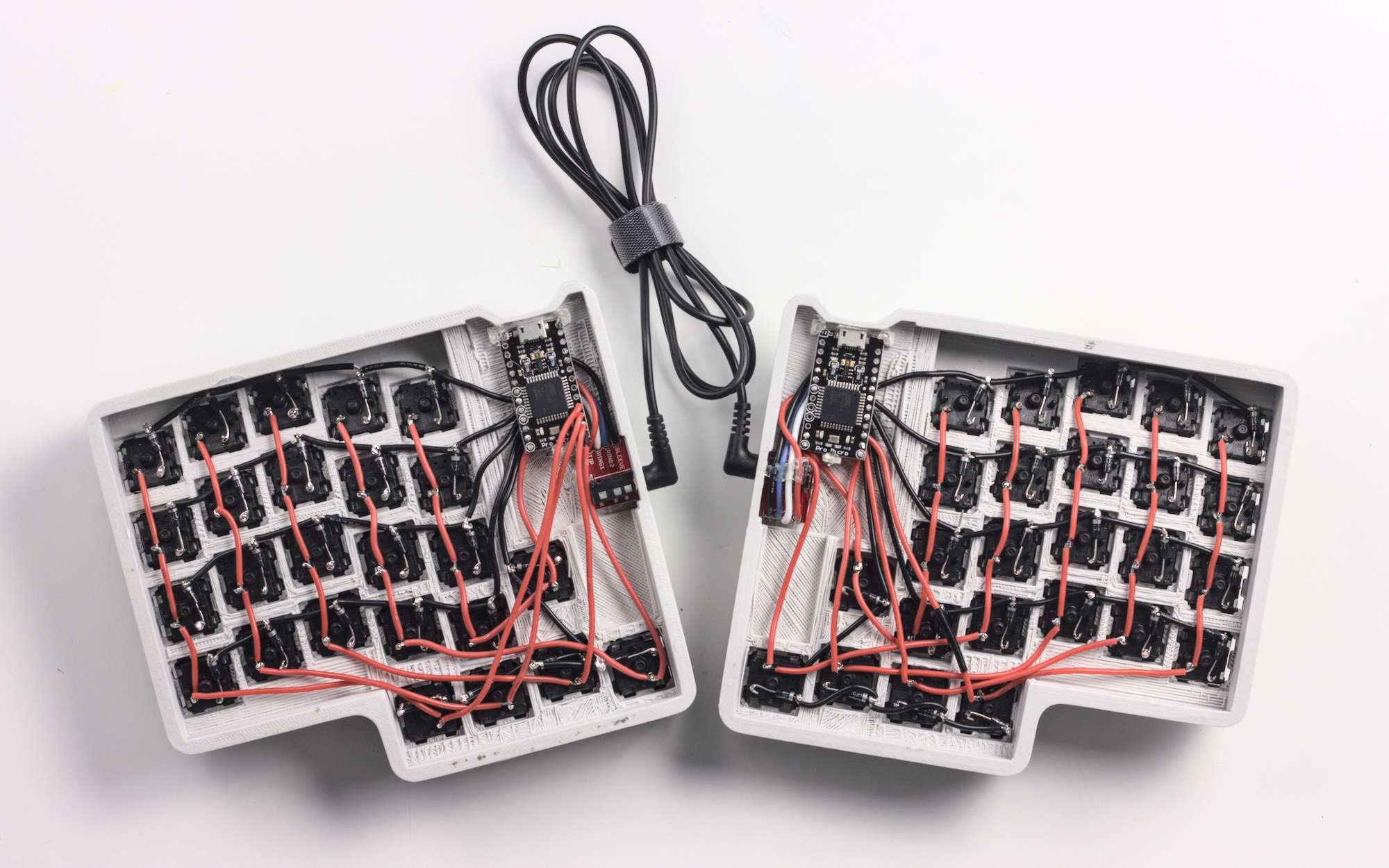 The hand-wired underside of the keyboard The underside of the split keyboard, showing exposed wiring to each key