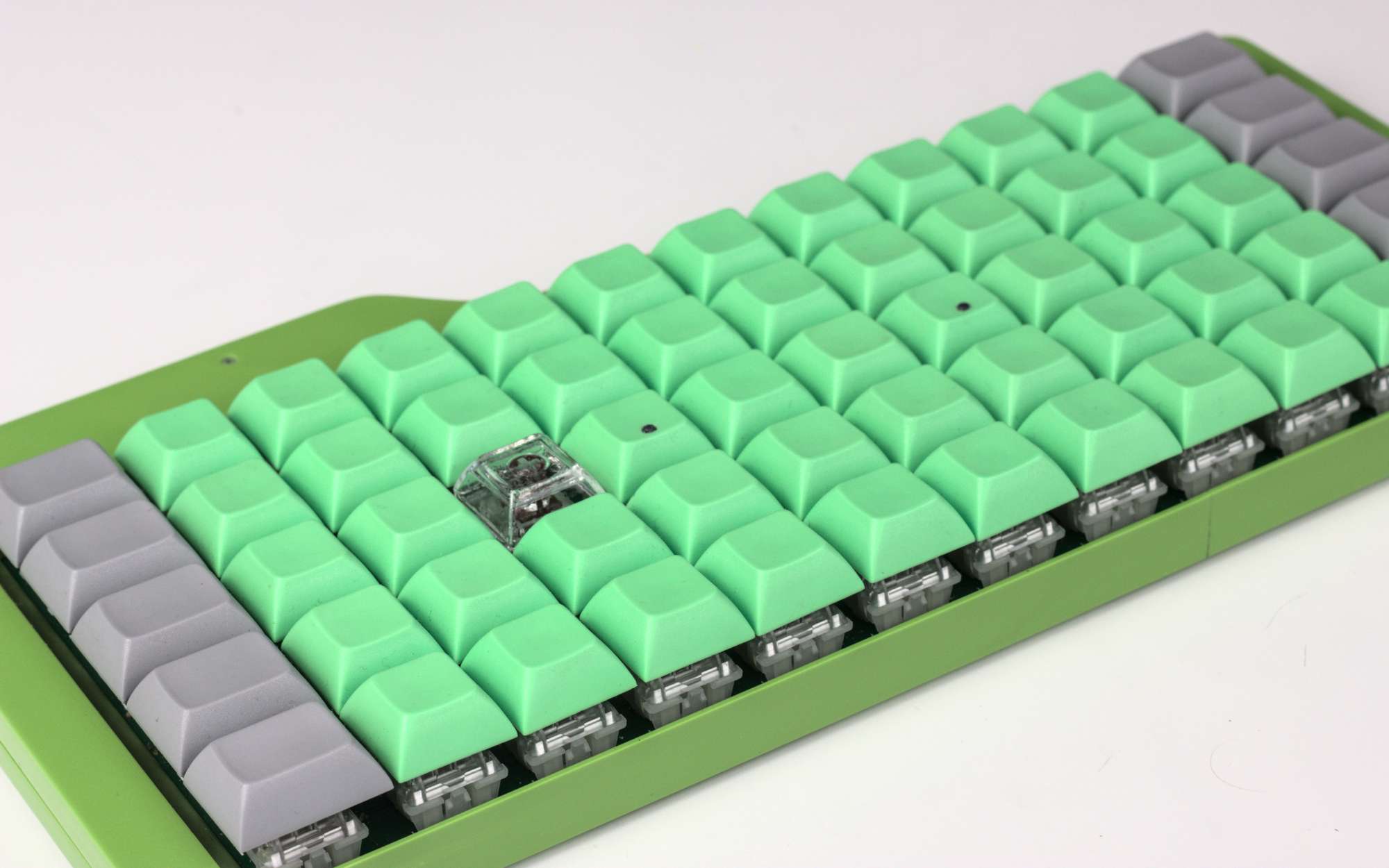 Clear polyester keycap in a sea of green ones Clear polyester keycap in a sea of green ones