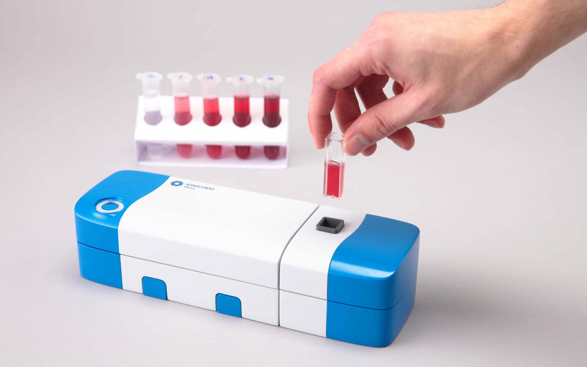 Installing a cuvette filled with a sample into the spectrometer, with an array of standards of increasing concentration in the background