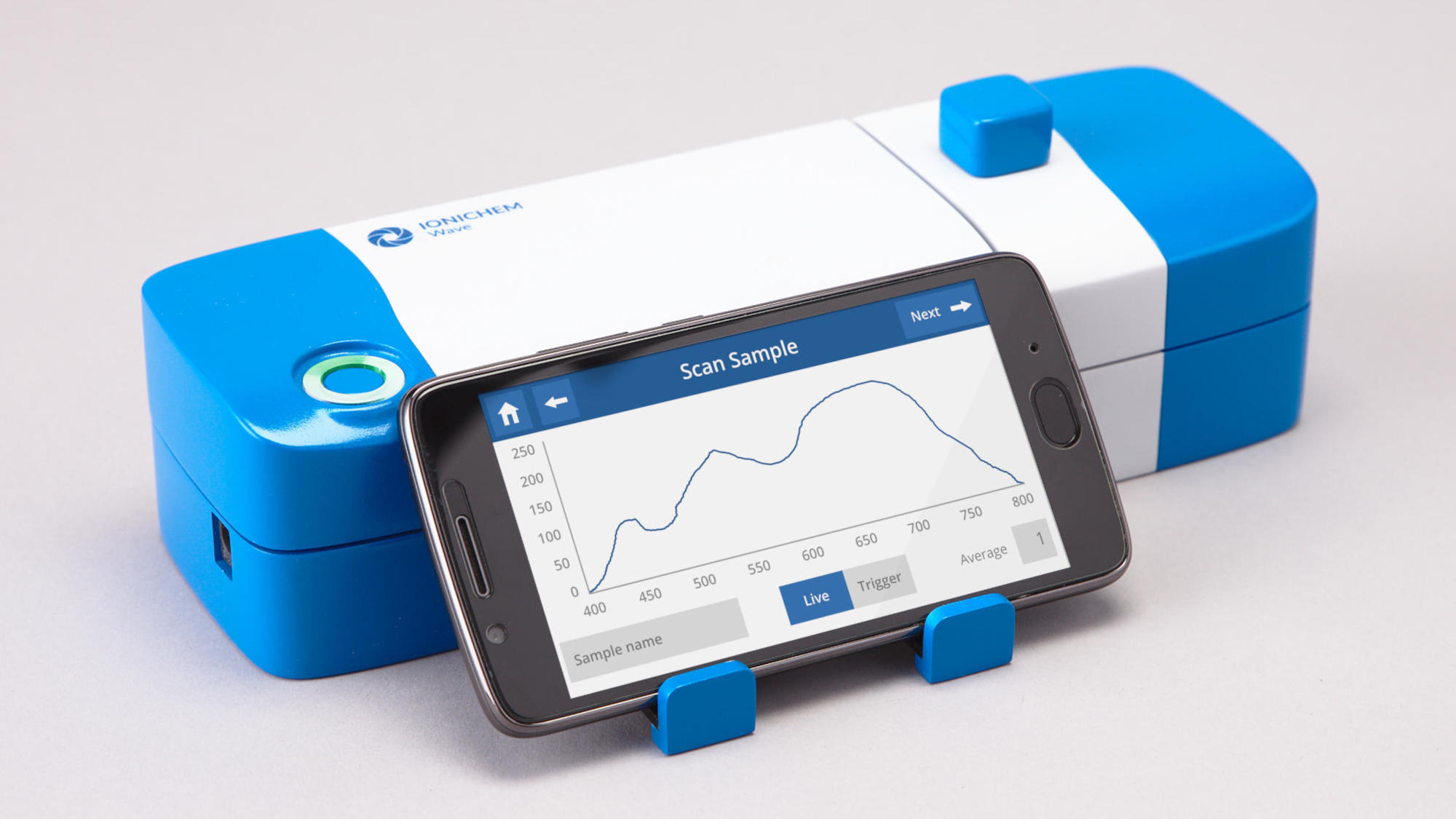 Blue and white spectrometer prototype with a phone showing a user interface